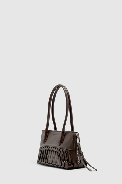 Side profile studio shot of the Brie Leon Faye Mini Tote in ganache dark brown recycled leather, showcasing the side expansion zipper with long leather pull tabs and structured dual handles.