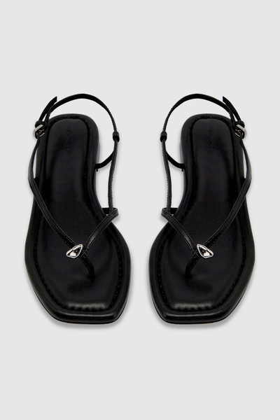 Top-down flat lay of the black recycled leather flat sandals featuring a squared toe, delicate crossover straps, and signature silver pebble hardware.