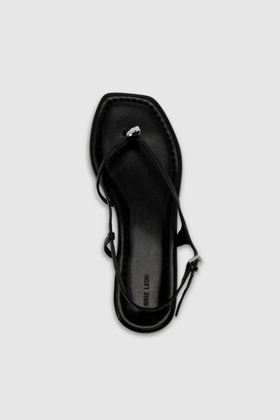 Top-down view of a single black recycled leather sandal highlighting the padded footbed and debossed "Brie Leon" branding.