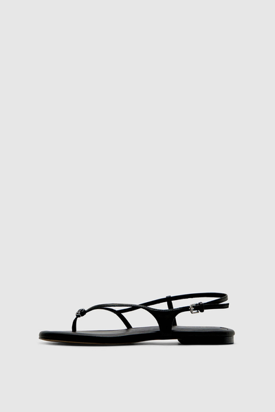 Side profile view of the black Halle flat sandal against a clean white background, showcasing the 1cm heel and refined silhouette.