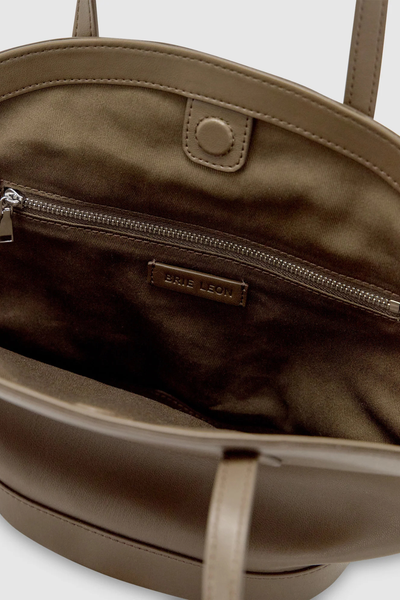Interior detail view of the open forest green Brie Leon Heather Mini Tote, displaying the tonal cotton twill lining, hidden magnetic snap closure, internal zip pocket with silver hardware, and debossed logo tab.
