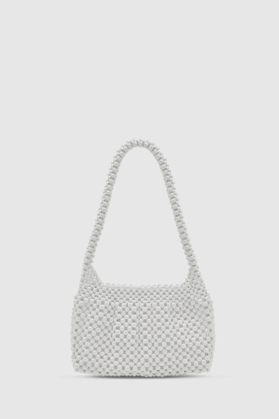 Studio front-facing product shot of the oat-colored lotus wood beaded mini bag against a clean white background, highlighting its compact, structured silhouette and top handle.