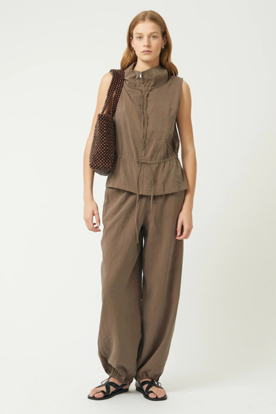 Studio full-length view of a model wearing a brown matching set and carrying the dark chocolate beaded tote bag over her shoulder.