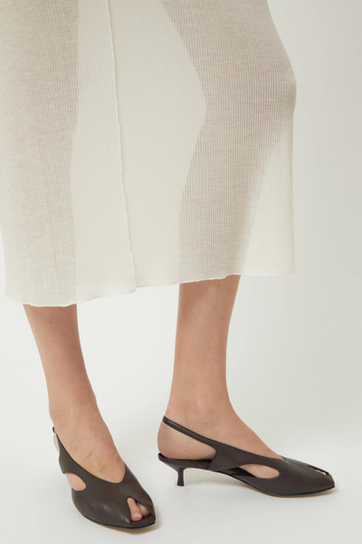 Cropped on-model view showing the dark chocolate brown Brie Leon Sadie Peep Toe Heels with side cut-outs and slingback heel straps, paired with a sheer cream knit maxi skirt.