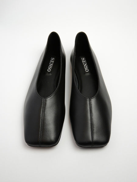 Top-down flat lay studio image of a pair of Senso Brynn black leather ballet flats, showcasing the high-cut square toe silhouette, center seam detail, and branded inner sole.