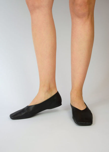 Side and front studio view on a white background showing Senso Brynn black leather ballet flats on foot, featuring a sleek flat profile and high-cut square toe line.