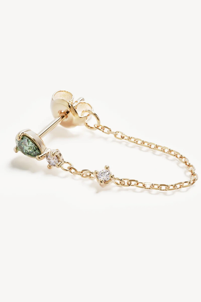 Close-up macro product shot of a single By Charlotte Aura Chain Earring in 18k Gold Plated laid flat, detailing the delicate fine link chain looped from the stud post to the butterfly backing.