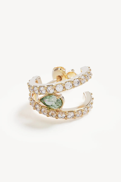 Macro close-up shot of a single By Charlotte Aura Illusion Hoop in 18k Gold Plated laid flat, highlighting the stud earring backing, pavé-set cubic zirconias, and bezel-set green tourmaline.