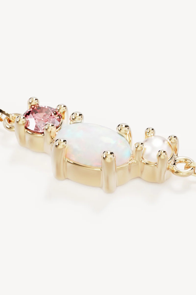 Extreme macro close-up product view detailing the claw-prong settings holding the round pink cubic zirconia, oval iridescent lab-grown opal, and freshwater pearl on the By Charlotte Cosmic Bloom Bracelet in 18k Gold Vermeil.