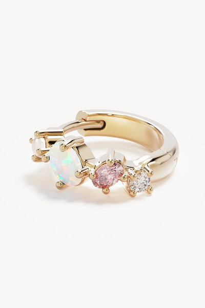 Macro close-up shot of a single By Charlotte Cosmic Bloom Hoop in 18k Gold Vermeil laid flat, detailing the multi-gemstone prong settings and polished finish.