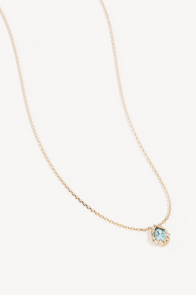 A full studio product photograph of the 18k Gold Plated Dive Deeper Necklace laid against a clean white background, showcasing the signature fine chain, lobster clasp, and the single organic teardrop pendant set with a vibrant blue-green gemstone.