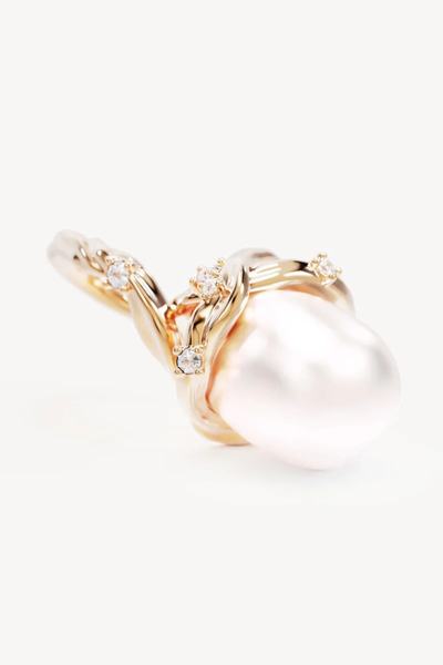 A macro close-up  shot of a single 18k gold vermeil pearl earring resting on its side, detailing the high-shine polished finish of the twisting wave-inspired gold casing and the unique, irregular surface texture of the 11-12mm baroque freshwater pearl.