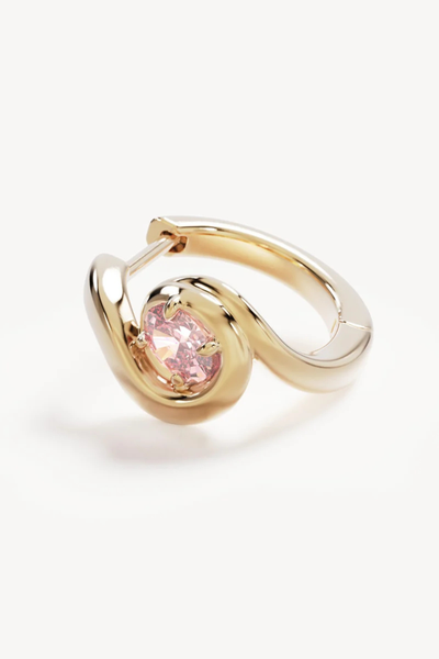 Macro close-up shot of a single By Charlotte Embrace Love Hoop in 18k Gold Vermeil, highlighting the polished organic swirl design surrounding a claw-set pink oval cubic zirconia.