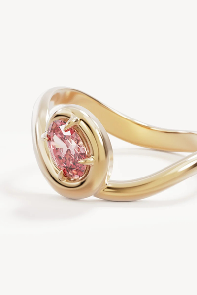 Macro close-up shot of the By Charlotte Embrace Love Ring in 18k Gold Vermeil, highlighting the faceted 6 x 4mm pink oval cubic zirconia and smooth polished gold finish.