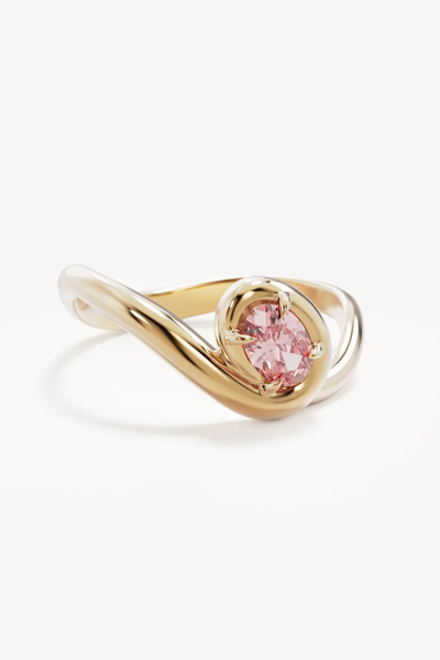 Studio product shot of the By Charlotte Embrace Love Ring in 18k Gold Vermeil on a white background, featuring a contoured bypass band with an oval-cut pink cubic zirconia setting.