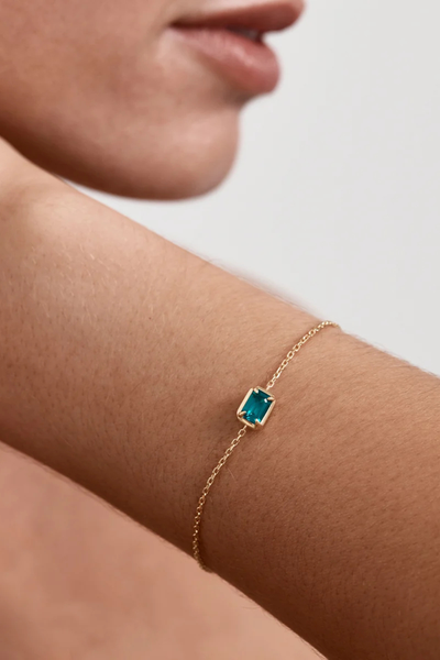 On-model lifestyle shot displaying the By Charlotte Trust Your Intuition Bracelet in 18k Gold Vermeil worn on a wrist, highlighting the vibrant green nano tourmaline Paraiba centerpiece stone.