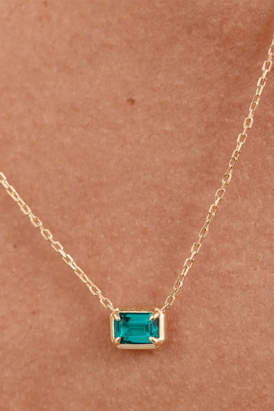 On-model close-up detail shot of the By Charlotte Trust Your Intuition Necklace in 18k Gold Vermeil, highlighting the deep green gemstone pendant against the skin.