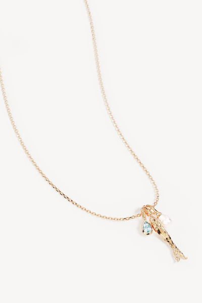 A flat lay studio product shot isolating the three individual charm pendants side-by-side on a white surface, providing a detailed look at the bale attachments of the bezel-set mint green teardrop gemstone, the sculpted 18k gold plated 'wish fish' anchovy charm, and the naturally shaped drop pearl charm.