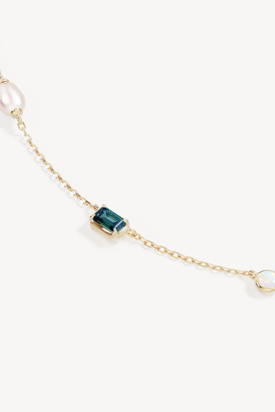 Close-up product detail of the By Charlotte You Are Infinite Choker in 18k Gold Plated, showcasing an emerald-cut nano tourmaline paraiba gemstone and bezel-set lab-grown opal station.