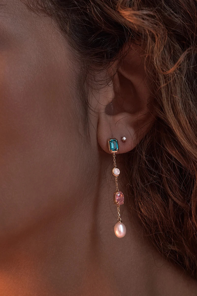 Warm-toned on-model profile view showcasing the By Charlotte You Are Infinite Drop Chain Earring in 18k Gold Plated styled alongside a small gold stud.