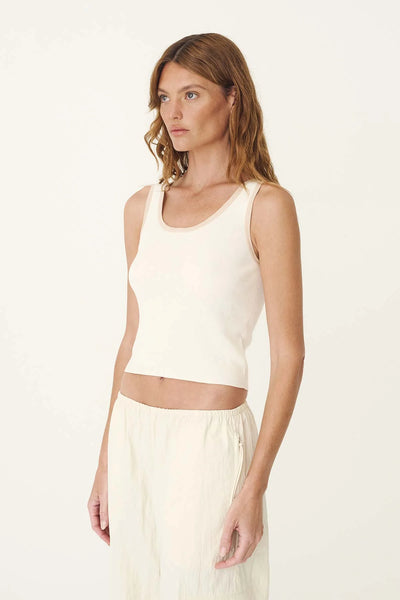 Three-quarter studio portrait of a model wearing the ROWIE Blake Contrast Knit Tank in Oat Milk, showing the fitted silhouette, scoop neckline, and flat cotton knit construction.