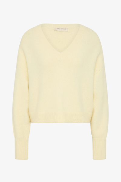 A slouchy Campbell V Cropped Jumper in a soft Butter yellow, featuring a wide V-neckline and a relaxed, cropped silhouette.