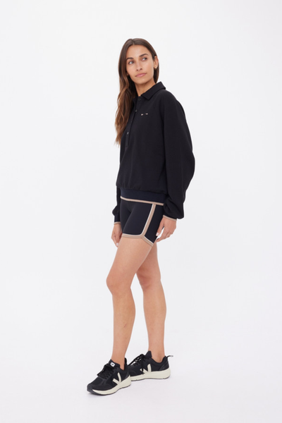 A side profile view showcasing the relaxed drape of the polo and the comfortable fit of the raglan sleeve construction.