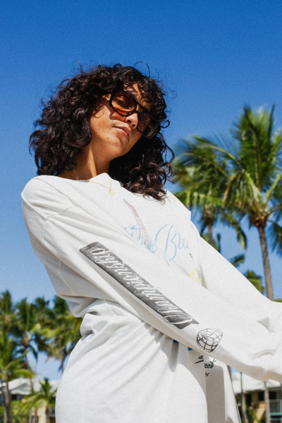 A full-length front view of the long sleeve top styled on a model, highlighting the relaxed yet tailored silhouette and how the vibrant blue color sits against a natural light studio backdrop.