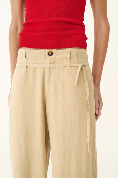 Close-up studio view of the waistband on the ROWIE Carlotta Linen Curve Pants in Khaki, showcasing the tortoiseshell button closure, zip fly, belt loops, and matching detachable thin tie belt.