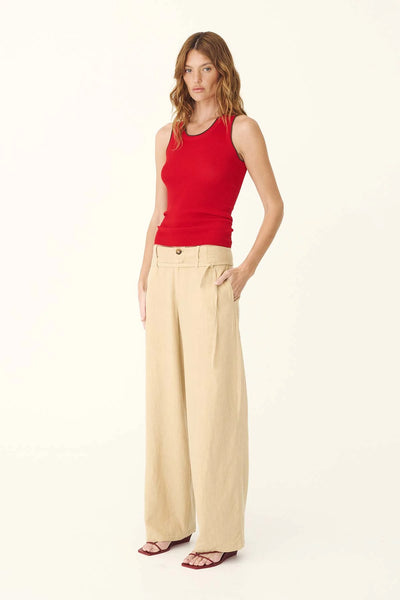 Three-quarter studio portrait of a model wearing the ROWIE Carlotta Linen Curve Pants in Khaki with a red top and sandals, showing the relaxed wide barrel-leg silhouette and side pockets.