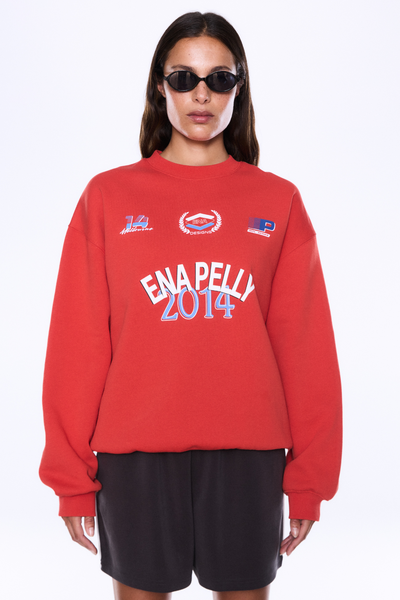 Medium front view of the ENA PELLY Mila Oversized Sweater in Vintage Red, highlighting the bold vintage-inspired logo artwork across the chest.
