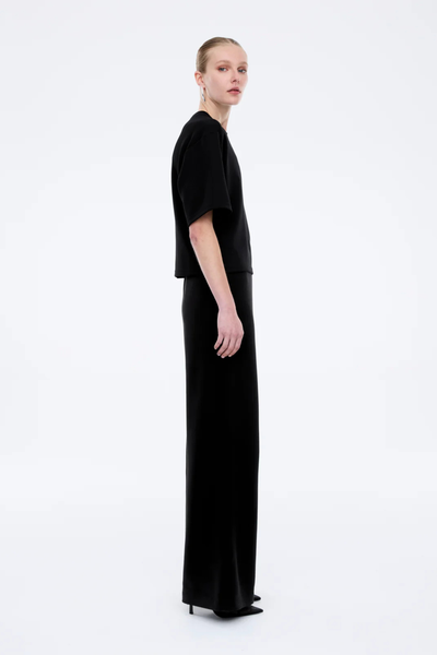 Rear view of the Alessa Relaxed Tee in black, illustrating the seamless back construction and the generous, straight-cut hemline.