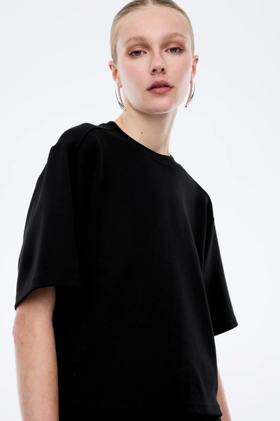 A close-up of the luxe black jersey material, highlighting the smooth, matte finish and the soft drape of the modal-blend fabric.