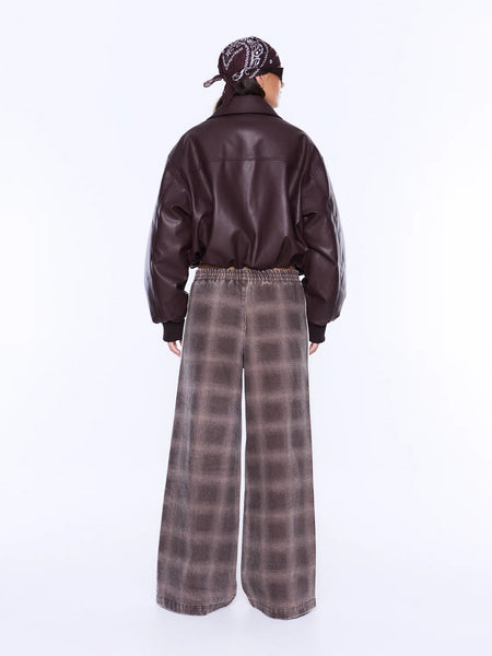 A full-length rear view studio shot of a model wearing the ENA PELLY Myla Wide Leg Pant in Burgundy Check, detailing the clean look of the pull-on style over the hips and the continuous flow of the all-over muted check print across the back.