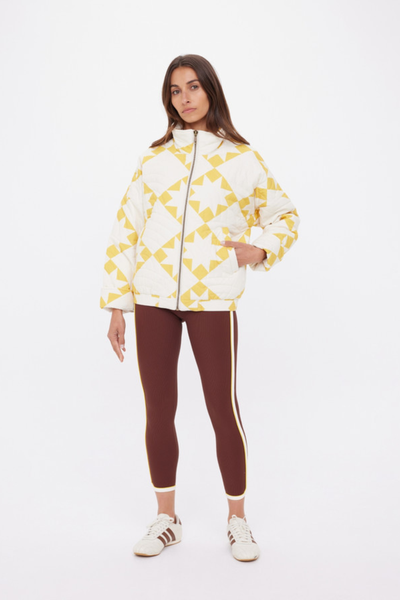 A front view of the oversized Etoile Carmen Quilted Jacket, showcasing the golden sand and cream star print with horizontal stripe quilting.