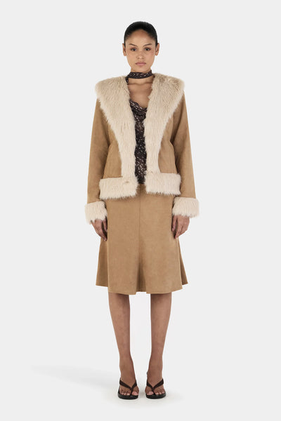 A full-length front studio view of a model wearing the Ownley Fifi Coat in Tan Cream, showcasing the wide faux fur shawl collar, structured mid-length silhouette, and matching cream fur accents at the cuffs and hemband.
