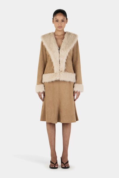 A full-length front studio view of a model wearing the Ownley Fifi Coat in Tan Cream, showcasing the wide faux fur shawl collar, structured mid-length silhouette, and matching cream fur accents at the cuffs and hemband.