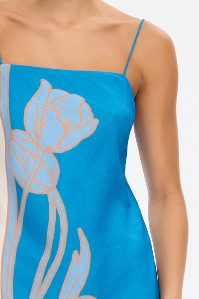 Detailed close-up shot of the KIVARI Fleur Mini Dress in Blue Ivory highlighting the linen-blend weave texture and blue flower artwork.