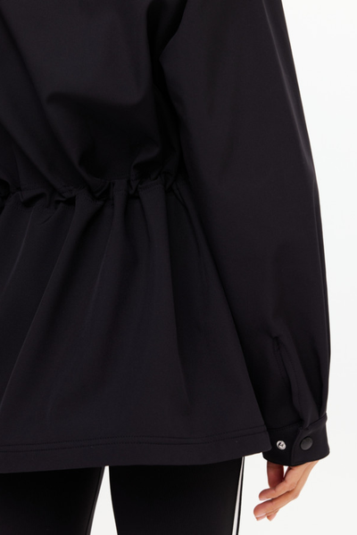 Close-up of the sleeve cuff and gathered waistline, illustrating the durable technical fabric and the adjustable snap-button cuff closures.