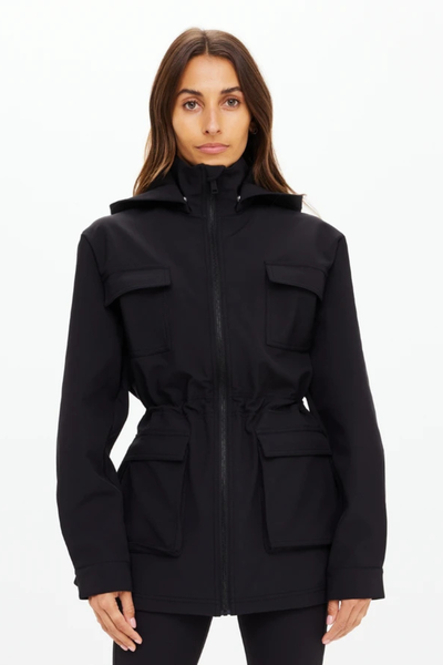 A three-quarter front view of the black anorak, highlighting the high-neck collar, integrated hood, and the structured yet comfortable athletic fit.