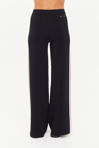 A full-length back view of the pants on a model, illustrating the consistent flow of the vintage Isla hibiscus print across the wide-leg silhouette and the comfortable drape of the lyocell-cotton blend.