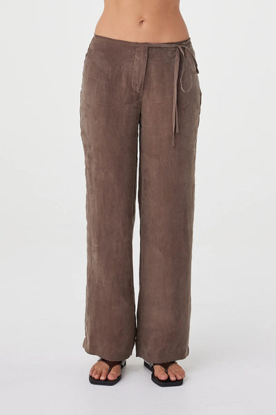 Waist-up front view of the pants emphasizing the waistband, delicate side ties, and minimal fly closure.