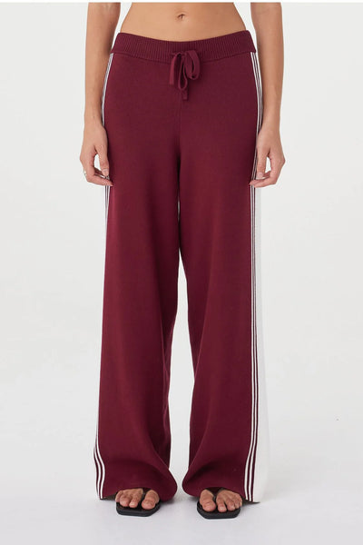 A detailed close-up shot from behind focusing on the upper waist of the Emery Pant. It showcases the secure fit of the ribbed merlot waistband and the clean finish of the knit fabric across the hips.