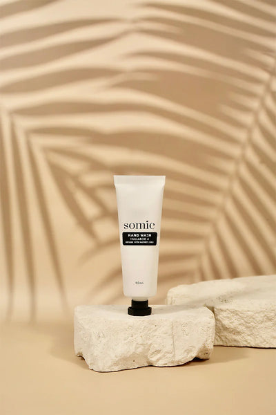 Tube of somic cream on a textured beige background