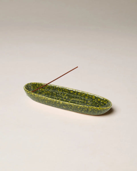 Studio product view of the Gentle Habits Collector Ceramic Incense Holder featuring a speckled green glaze finish holding an incense stick against a neutral backdrop.