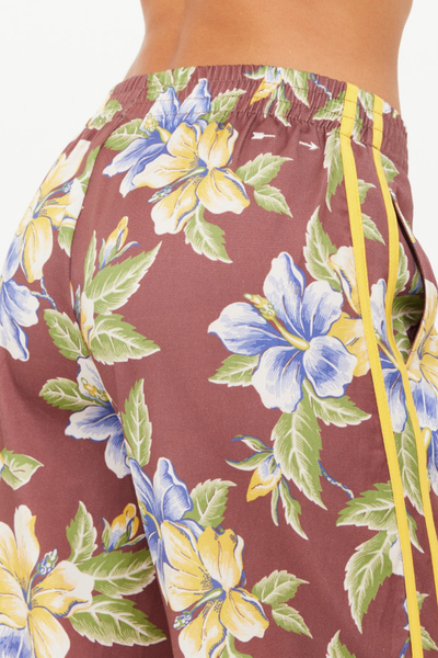 A close-up shot of the rear waistband, illustrating the gathered elastic waist, side seam pocket entry, and the subtle white embroidered arrow logo.