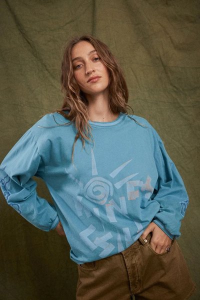 Three-quarter studio portrait of a model wearing the oversized Kinga Csilla Paper Sun Roses Tee in Blue, showing the crew neckline and dropped shoulder detail.