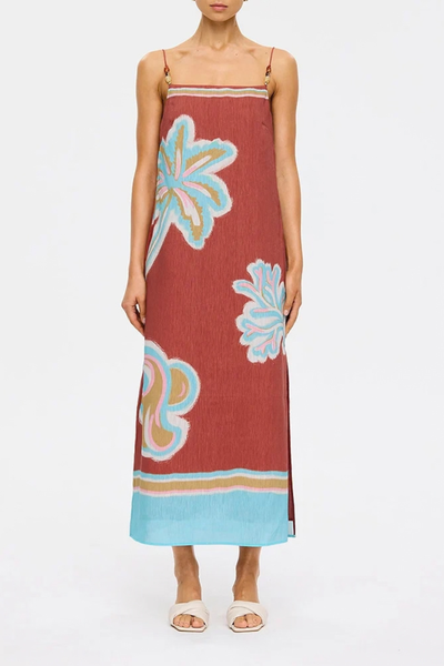 Studio front three-quarter view of a model posing in the relaxed column midi dress, highlighting the straight neckline and statement tropical print.