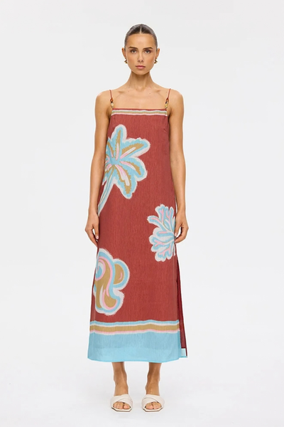 Studio front full-length view of a model standing in the maroon linen-viscose Enzo midi dress paired with neutral mules.