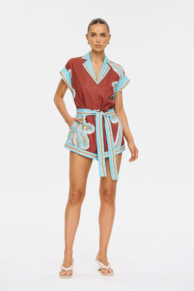 Studio front three-quarter view of a model posing with hands in the side pockets of the Enzo playsuit.